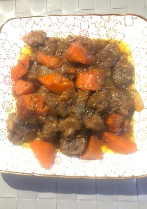A picture of Braised beef ribs with onion and carrot.