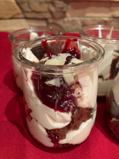 Una foto de Crema de queso con reducción de frutos rojos y crumble de chocolate