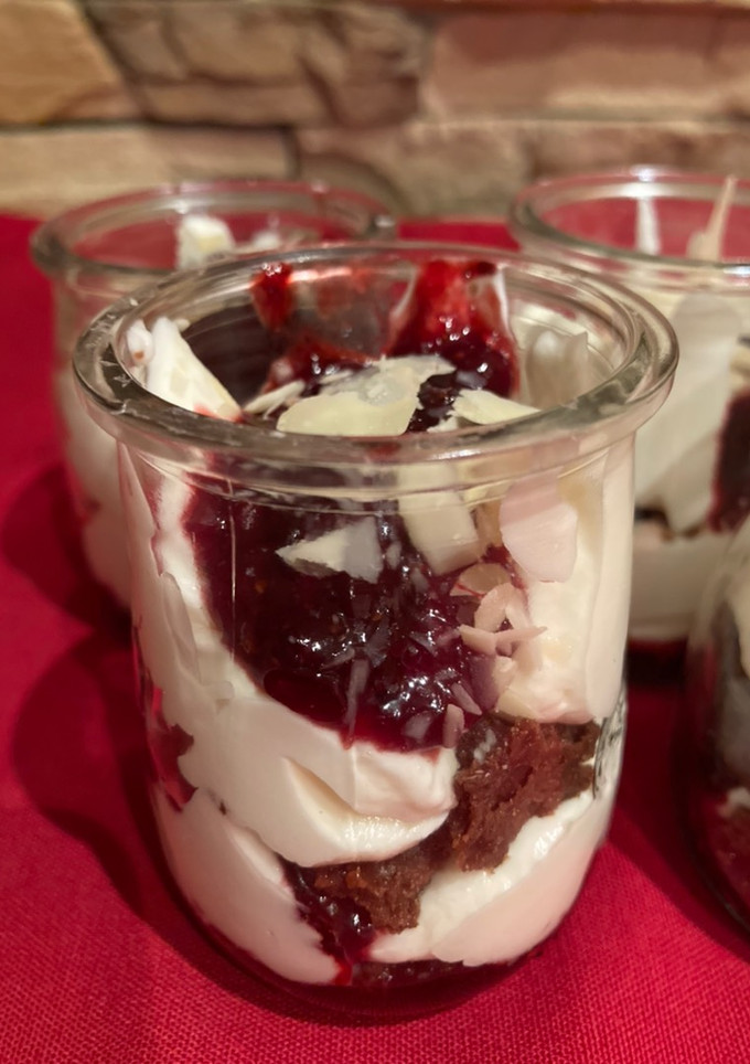 Una foto de Crema de queso con reducción de frutos rojos y crumble de chocolate