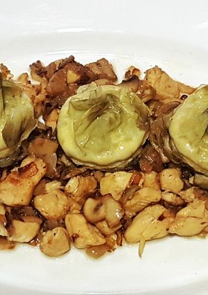 Una foto de Corazones de alcachofa con lecho de pollo, cebolla y champiñones