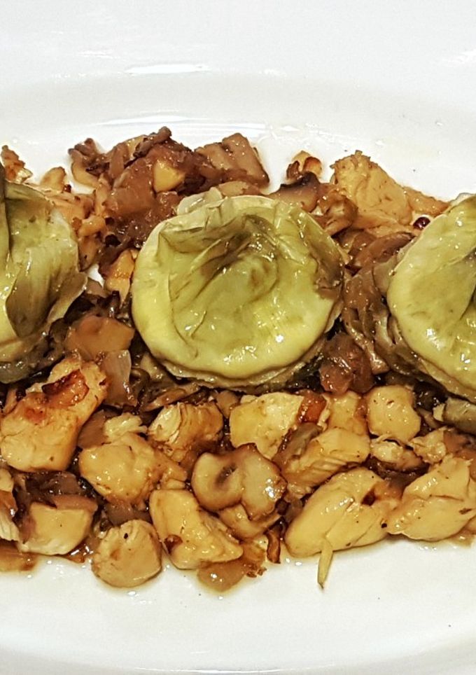 Una foto de Corazones de alcachofa con lecho de pollo, cebolla y champiñones