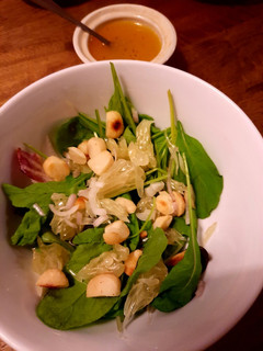 A picture of Mixed greens and pomelo salad with passionfruit dressing.