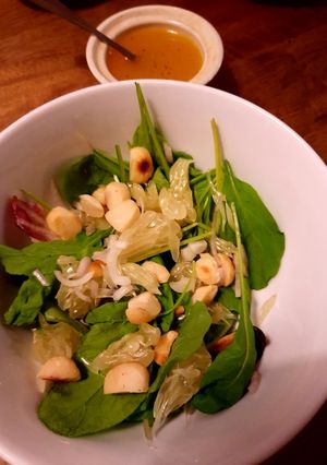 A picture of Mixed greens and pomelo salad with passionfruit dressing.