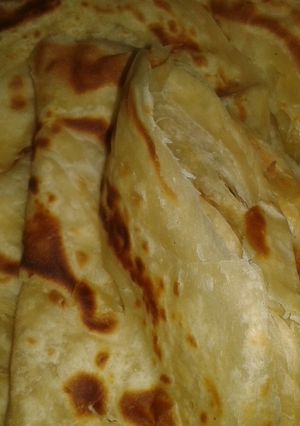 A picture of Chapati (Soft, layered) served with coconut beans.