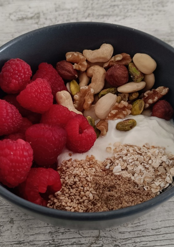 Una foto de Yogur con fruta, frutos secos, semillas y avena