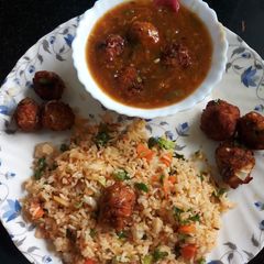 A picture of Veg fried rice with Manchurian in gravy.