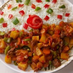 A picture of Garnished white rice with Potato soup.
