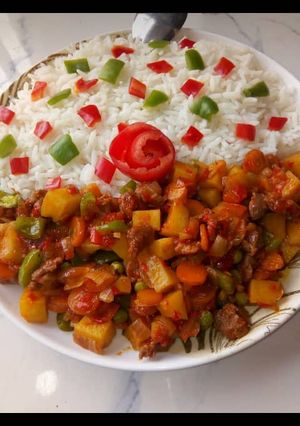 A picture of Garnished white rice with Potato soup.