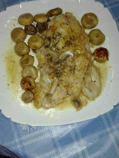 Una foto de Mero a las finas hierbas en su jugo con champiñones
