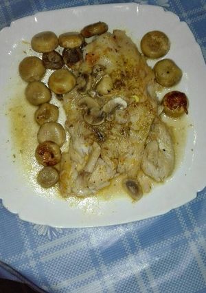 Una foto de Mero a las finas hierbas en su jugo con champiñones