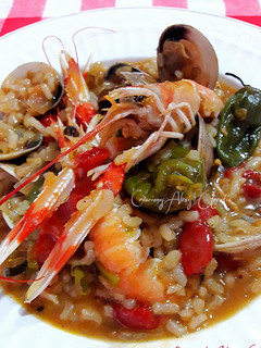 Una foto de Arroz con jugos de cigalas, almejas y pimientos tipo padrón