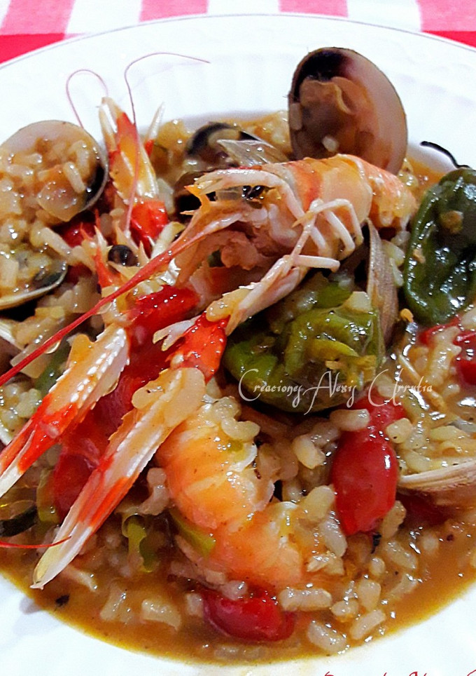 Una foto de Arroz con jugos de cigalas, almejas y pimientos tipo padrón