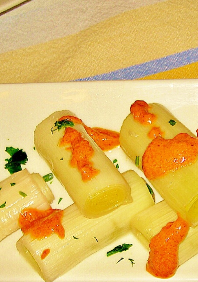 Una foto de Puerros y cebolletas al horno en salsa romesco