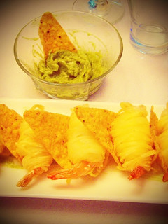 Una foto de Hilos de patata envueltos sobre langostino y salsa guacamole