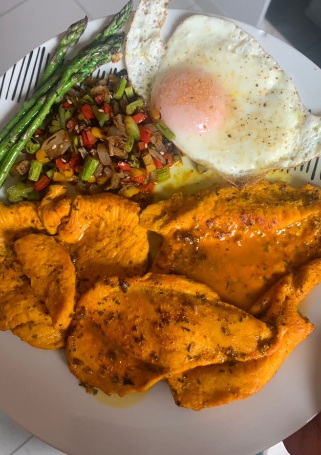 Una foto de Pechuga de pollo con especias, verduras y huevo a la plancha