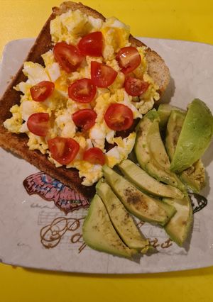 A picture of Scrambled eggs on toast and avocado.