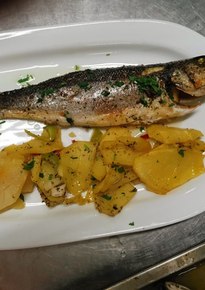 Una foto de Lubina al horno con limón y patatas panaderas