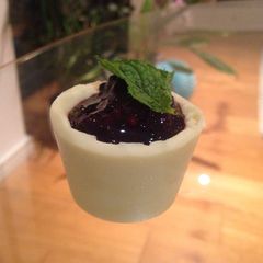 A picture of Solid white chocolate pots with blackberry and mint compote.