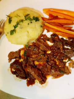 A picture of Wetfried beef, mashed potatoes and carrot sticks.