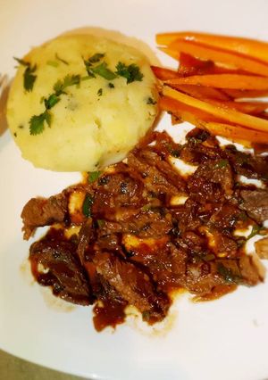 A picture of Wetfried beef, mashed potatoes and carrot sticks.