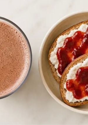 Una foto de Licuado de leche, proteína, avena y cacao + tostadas con ricota