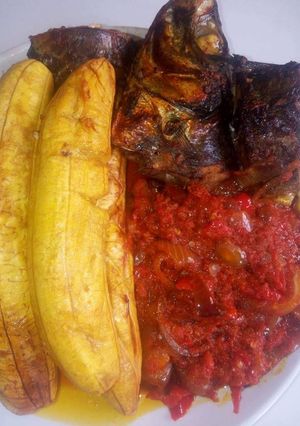 A picture of Grilled plantain with titus fish and pepper sauce.