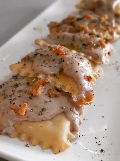 Una foto de Raviolis caseros de pies de cerdo con gambas y bechamel de ceps