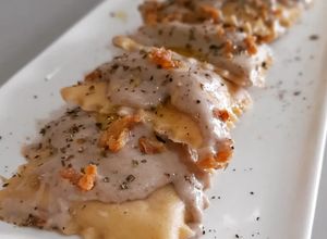 Una foto de Raviolis caseros de pies de cerdo con gambas y bechamel de ceps
