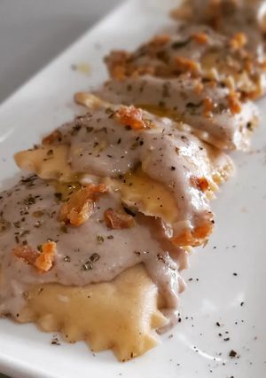 Una foto de Raviolis caseros de pies de cerdo con gambas y bechamel de ceps