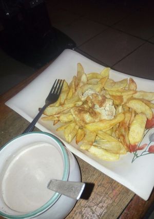 A picture of Potato chips and fried egg with tea.