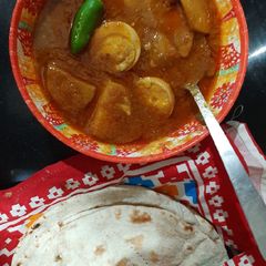 A picture of Aloo anday ka salan with tandoori roti.
