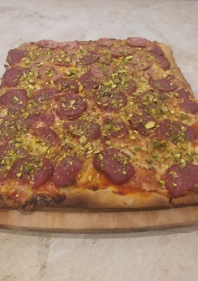Una foto de Pizza casera con pistachos