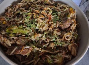 Une photo de Nouilles sautées au bœuf et légumes à la sauce soja en cocotte