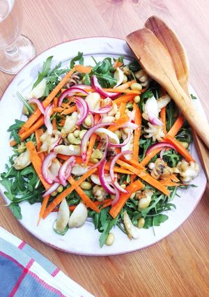 Una foto de Calamares flambeados en ensalada multicolor