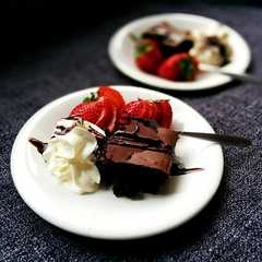 Una foto de Postre de brownie, frutillas y crema 🍫🍎