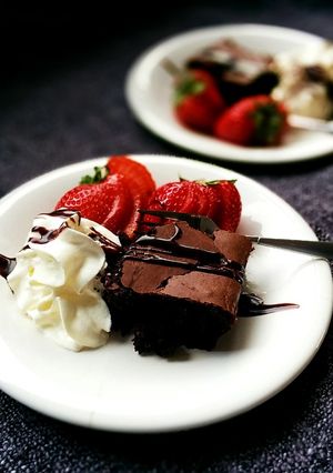Una foto de Postre de brownie, frutillas y crema 🍫🍎