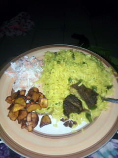 A picture of Fried rice,plantain and coleslaw.