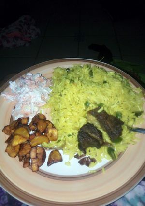 A picture of Fried rice,plantain and coleslaw.