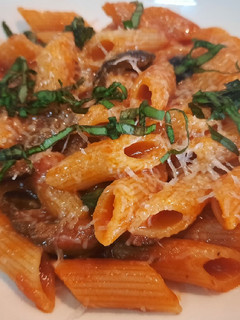 Una foto de Penne rigate con tomate a la albahaca, parmesano y aceitunas