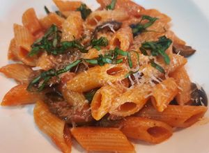 Una foto de Penne rigate con tomate a la albahaca, parmesano y aceitunas