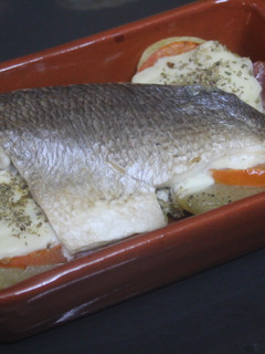 Una foto de Dorada al horno con patatas y tomate