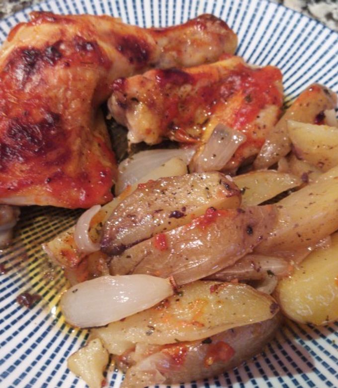 Una foto de Muslos de pollo asados con gajos de patata