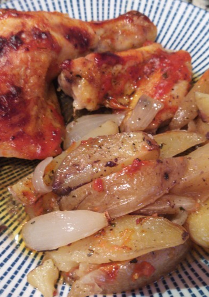 Una foto de Muslos de pollo asados con gajos de patata