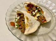 Una foto de pan árabe con carne y cebollas