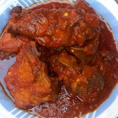 A picture of Tomato stew with chicken.