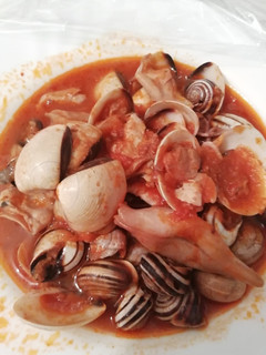 Una foto de Calamares en salsa americana con almejas y caracoles