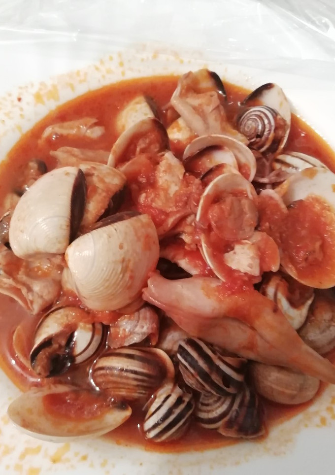 Una foto de Calamares en salsa americana con almejas y caracoles