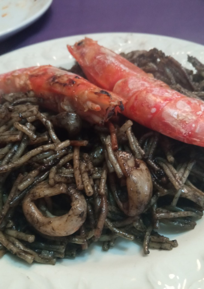 Una foto de Fideuà negra de marisco