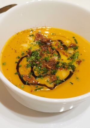 Una foto de Crema de moniatos i porros amb cruixent d'ibèric i parmesà