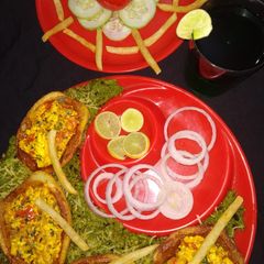 A picture of Potato boat loaded with paneer bhurji in green peas gravy.